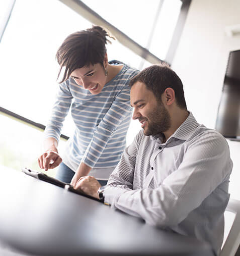 Woman co-worker coaching a male co-worker